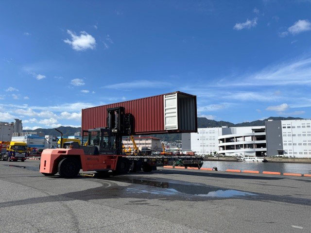 コンテナを持ち上げるフォークリフト