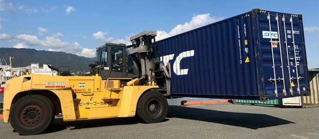 コンテナを持ち上げるフォークリフト